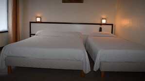 A hotel room with two single beds, a painting on the wall, and two bedside lamps. - Hôtel Avenir Vaugirard (Paris)