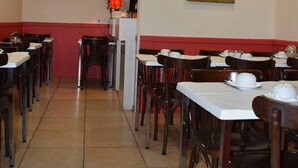 A restaurant with tables and chairs, a television displaying the number 7, and a painting on the wall. - Hôtel Avenir Vaugirard (Paris)