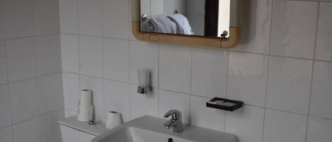A bathroom with a toilet, sink, and bathtub.
