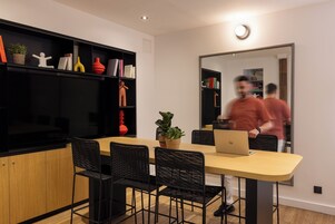 Una cucina moderna con un tavolo da pranzo, sedie nere e un portatile sul tavolo.