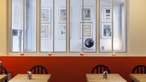 Un restaurant avec un mur rouge et une fenêtre ornée de cadres contenant des photos.