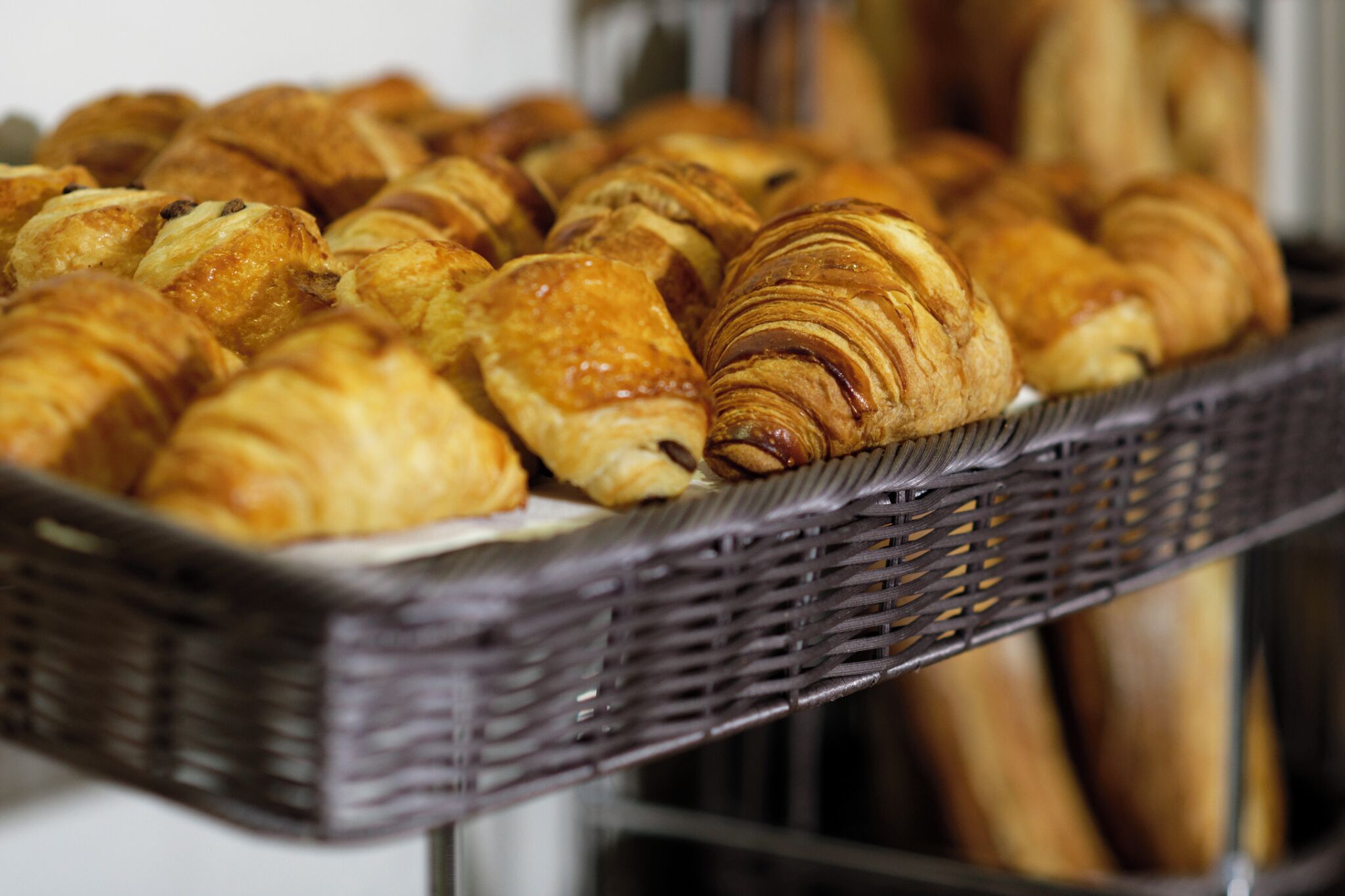 A basket of assorted pastries, including croissants and other baked goods.