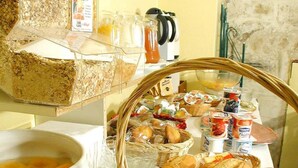 Ein reichhaltiges Frühstücksbuffet mit Brot, Gebäck und Getränken.