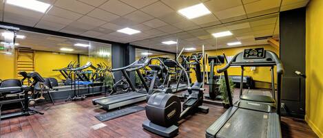 Un gimnasio con cintas de correr, elípticas y estaciones de pesas.