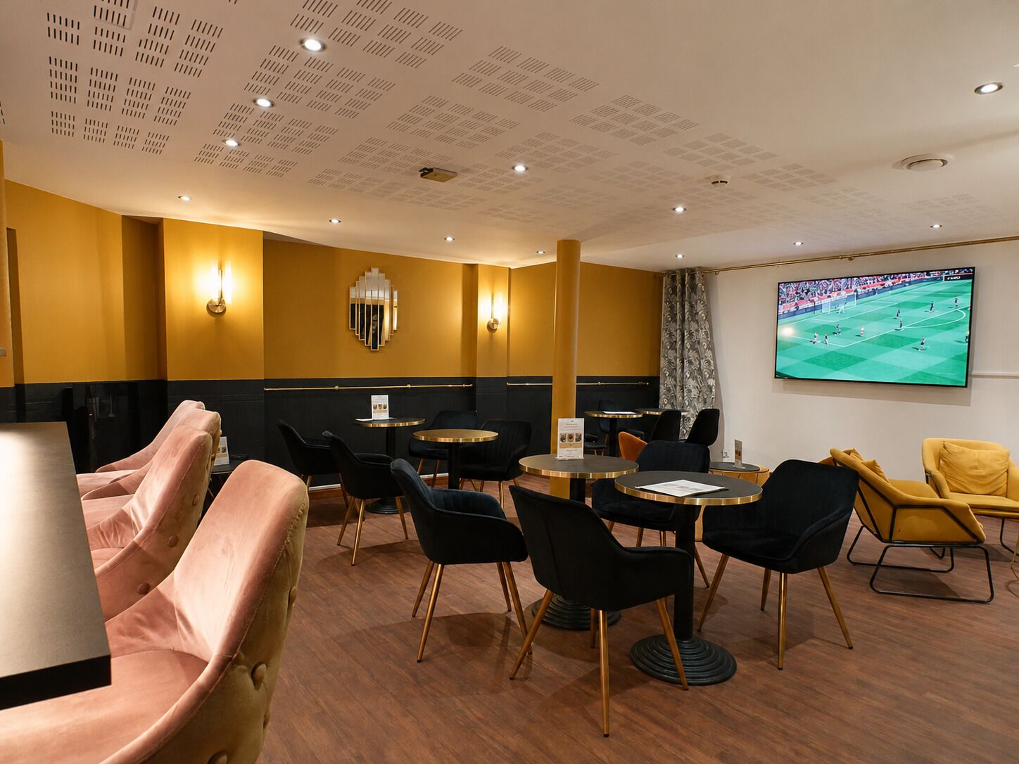 Une chambre d’hôtel dotée d’une grande télévision, de sièges confortables et d’un design moderne.