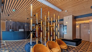 A lobby with a geometric patterned floor, a reception desk, and modern seating.