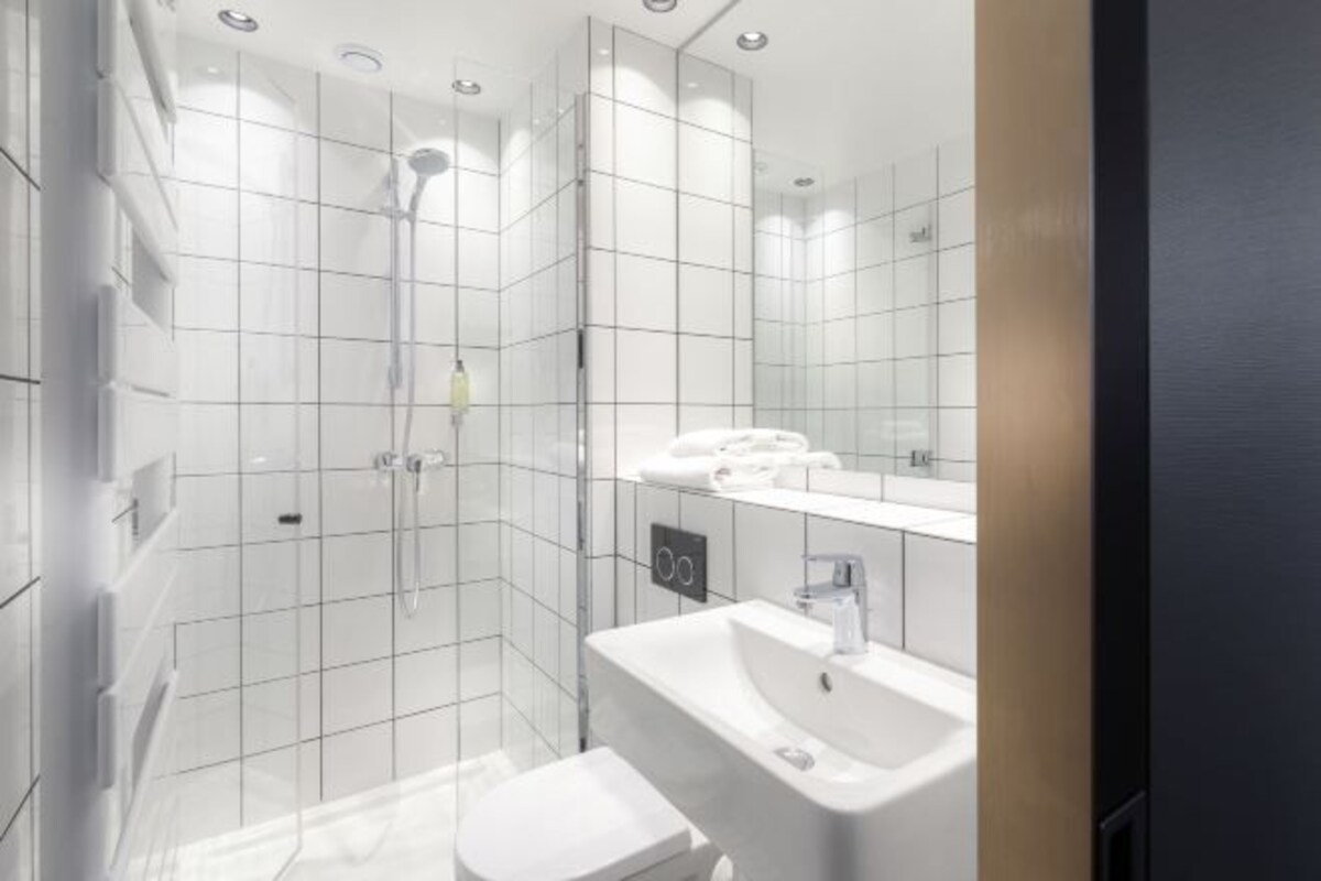 Een moderne badkamer met douche, toilet en wastafel.
