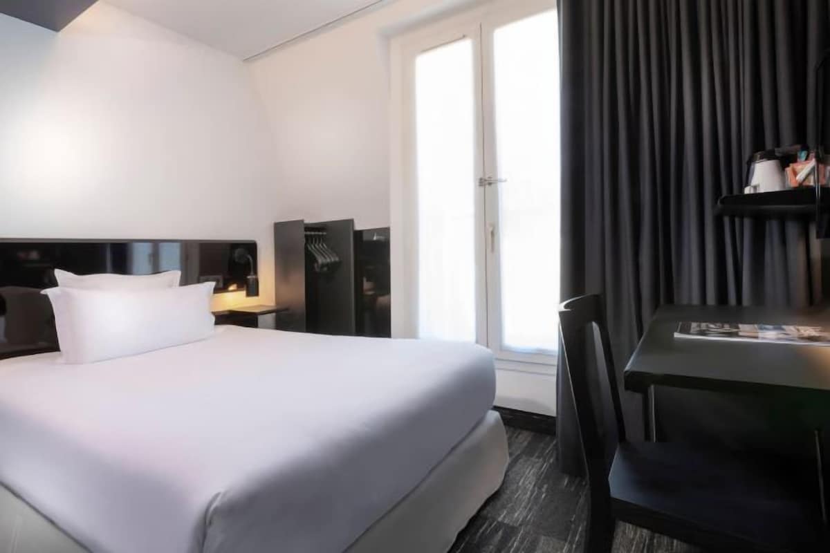 Ein Hotelzimmer mit einem Bett, einem Schreibtisch und einem Stuhl.