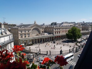 A historic building with a large arched entrance, a central courtyard, and a street in front.
