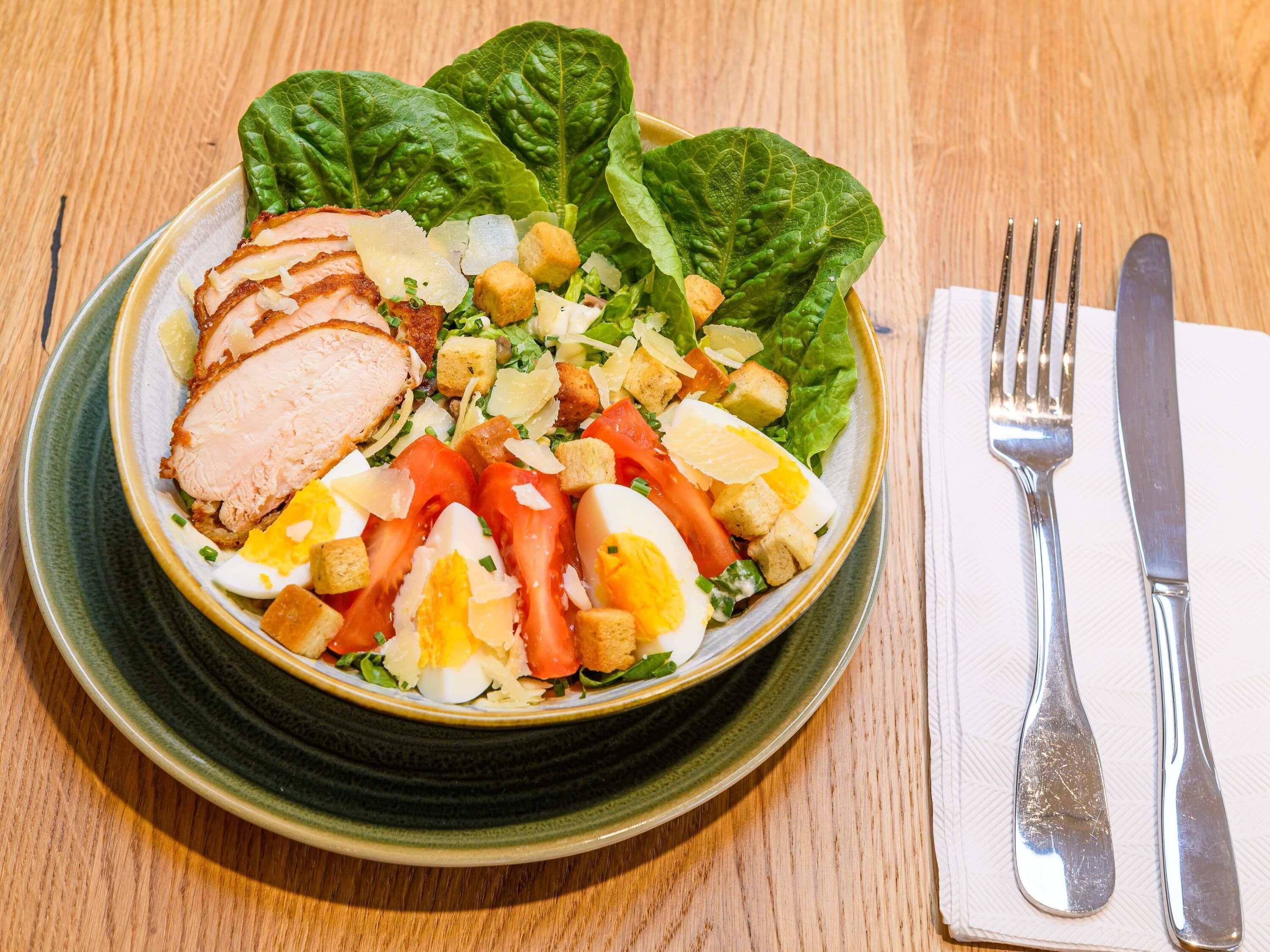 A plate of food with sliced meat, eggs, and vegetables.