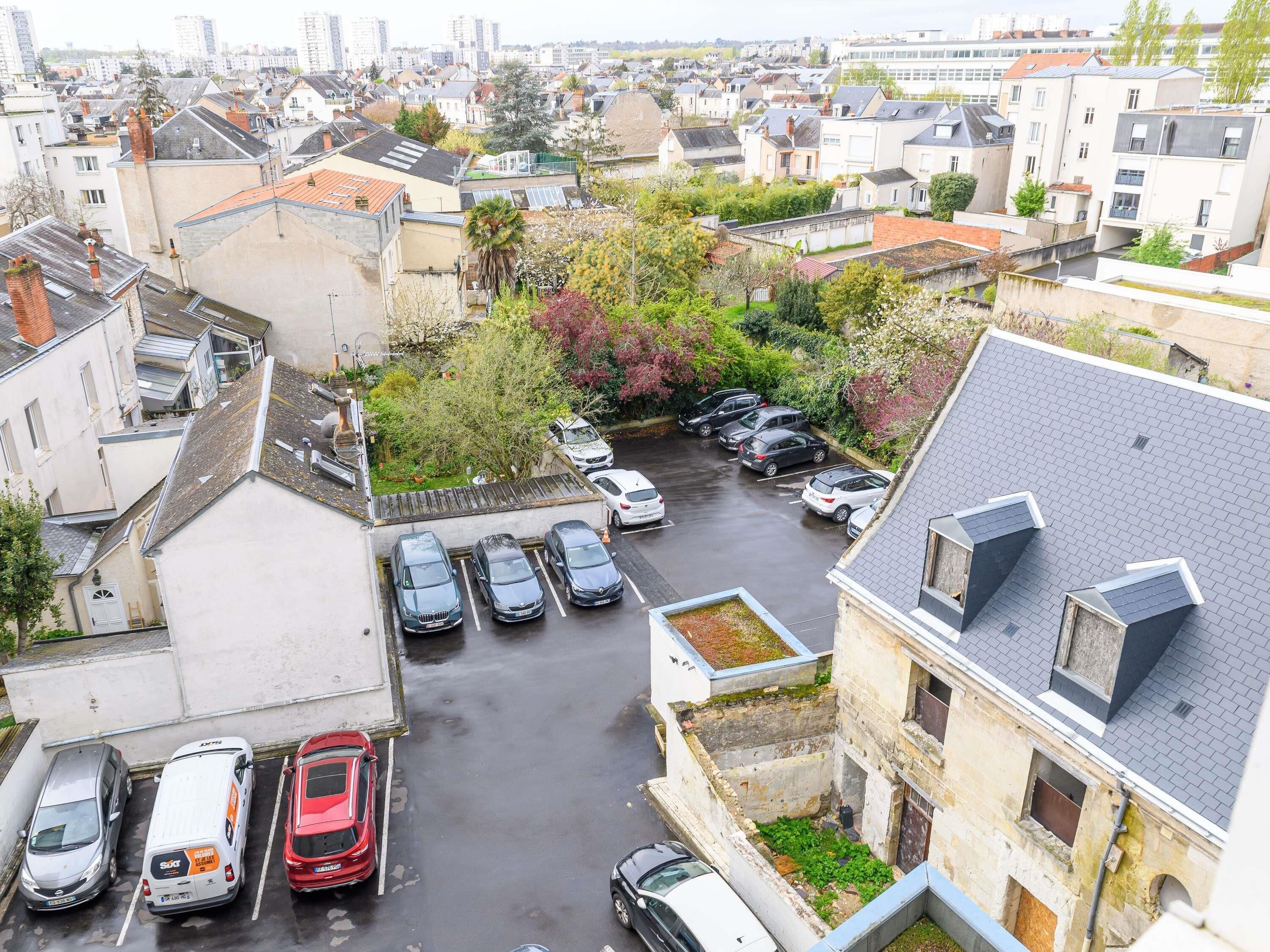 Zona residencial con estacionamiento, casas y una combinación de arquitectura moderna y tradicional.