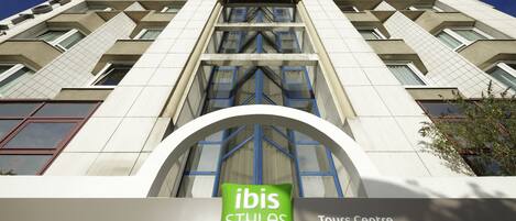 A hotel facade with a prominent 'ibis Styles Hotels' sign and a 'Tours Centre' sign.