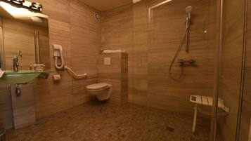 Une salle de bain avec une douche à parois de verre, des toilettes, un lavabo avec un récipient en verre et un miroir.