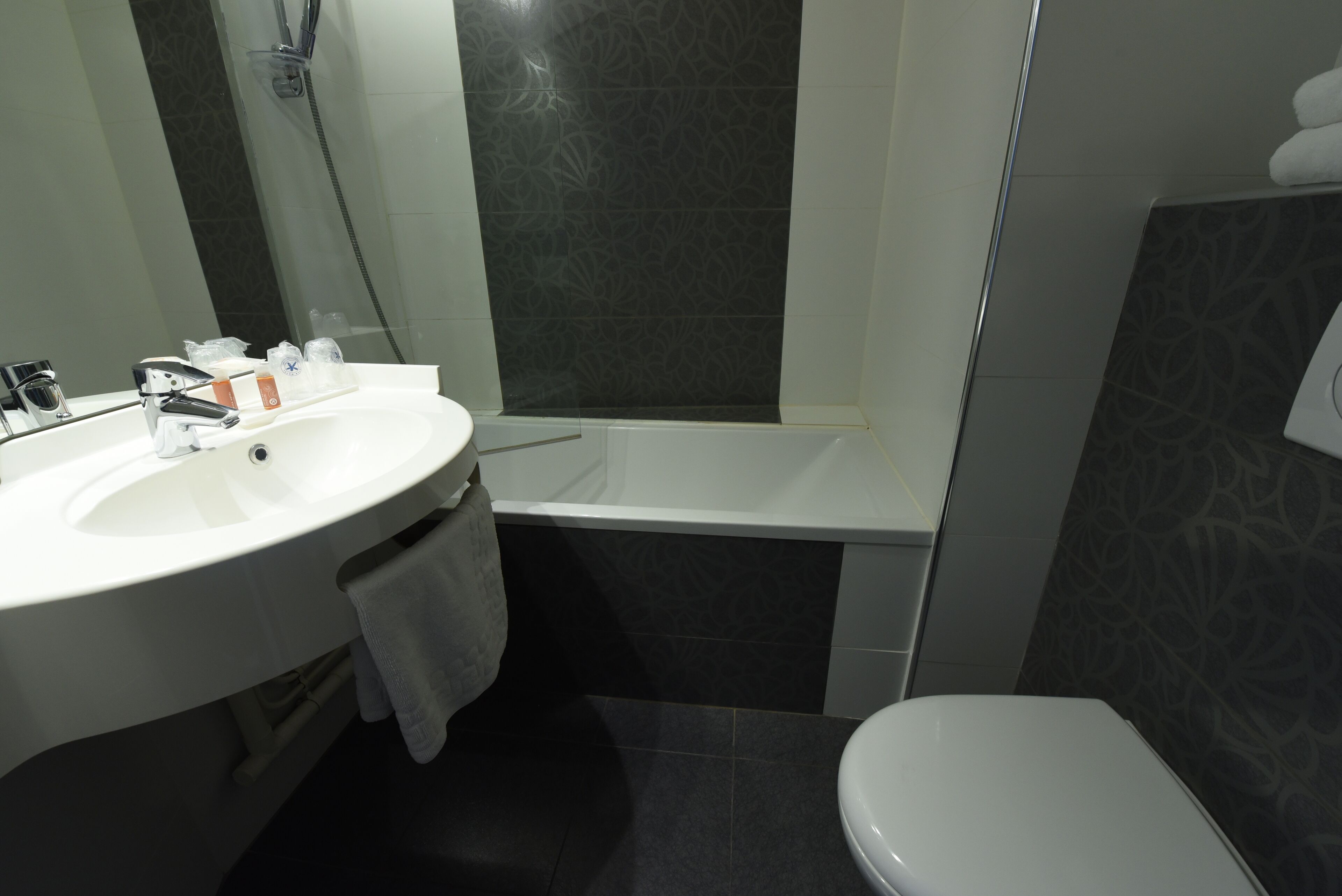 Une salle de bain avec un lavabo blanc, une baignoire et des toilettes.