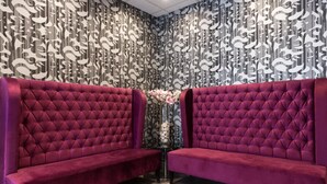 A room with two tufted red sofas, a patterned wall, and a small table with a vase. - Relais St Eloi, Sure Hotel Collection by Best Western (Tours)