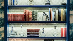 A bookshelf with books, a globe, and a trophy.