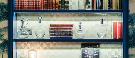 Una estantería con libros, un globo terráqueo y un trofeo.