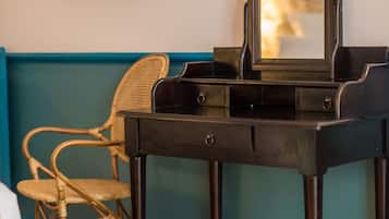 Una habitación con un piano, un televisor y una silla de mimbre.