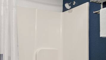 A bathroom with a bathtub, toilet, and a shower curtain.