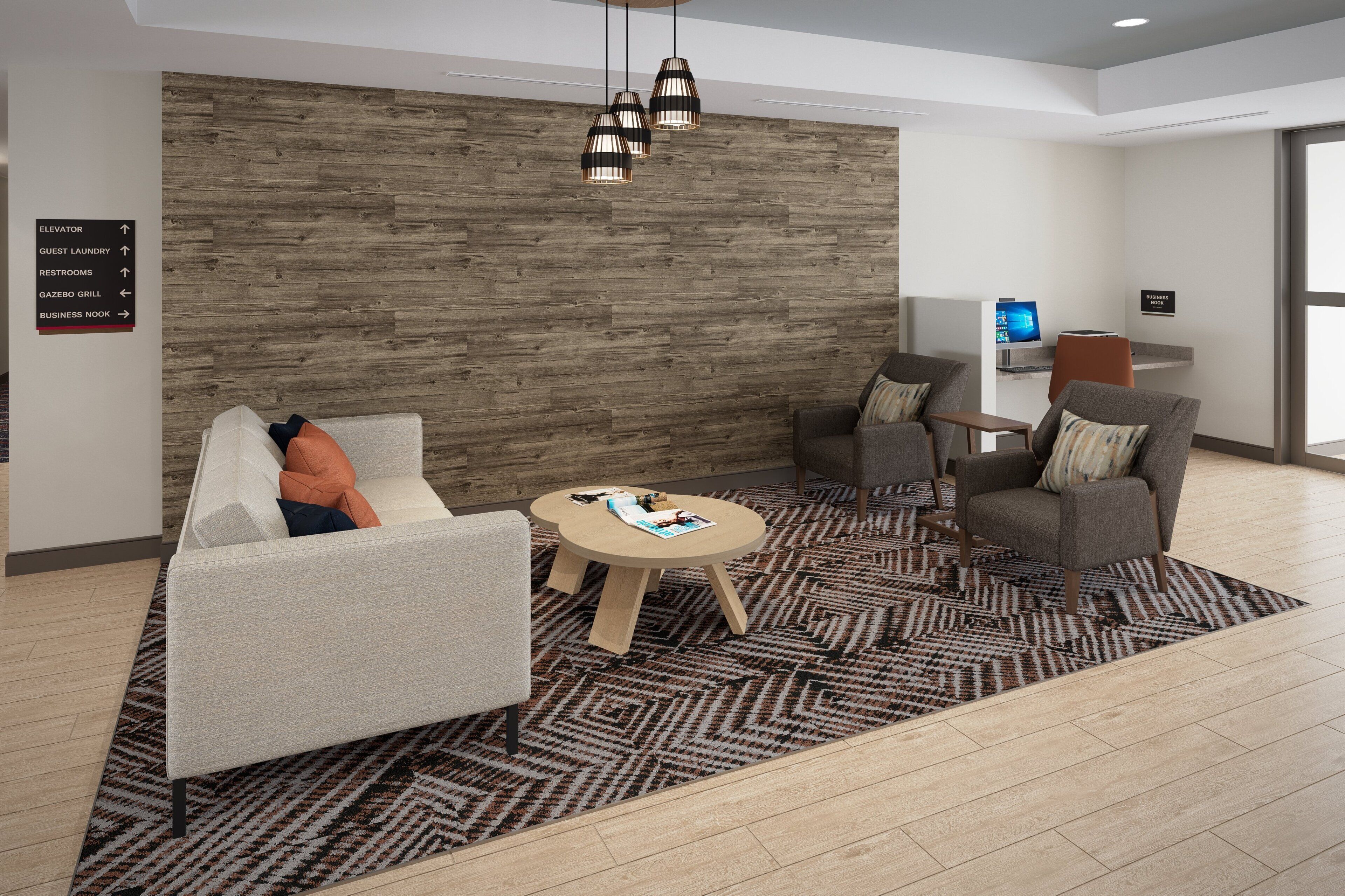 A modern lobby with a wood panel wall, a seating area with sofas and a coffee table, directional signs, and a reception desk.
