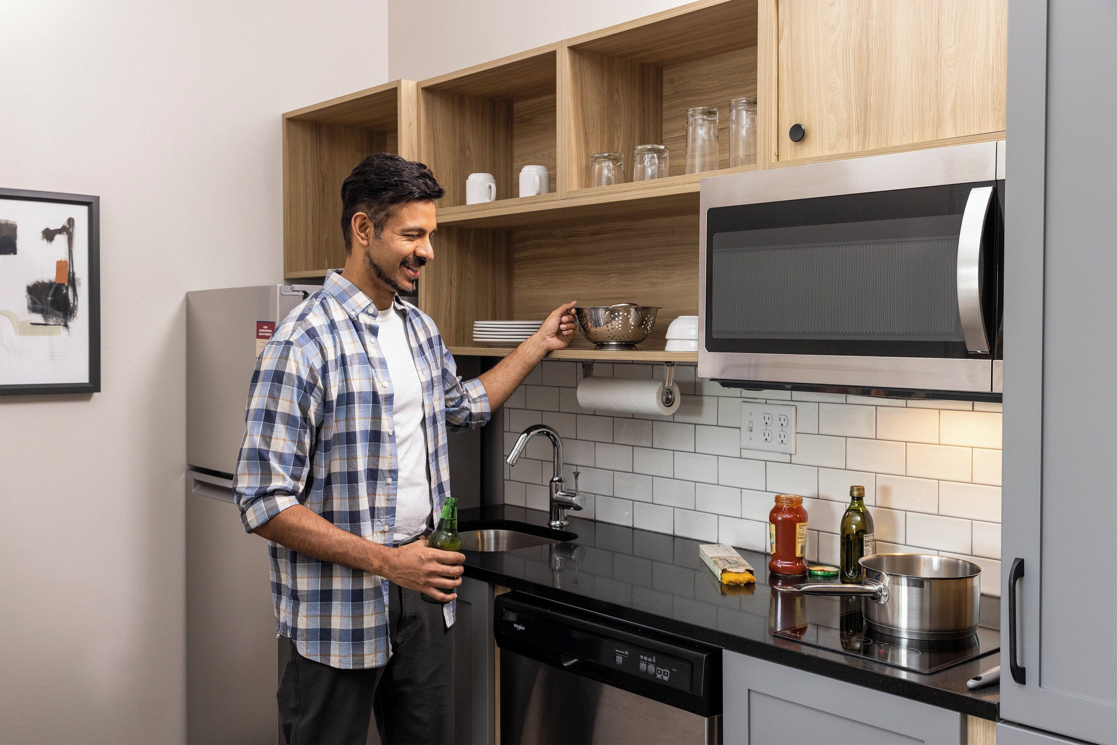 A modern kitchen with wooden cabinets, a built-in microwave, and a dishwasher.