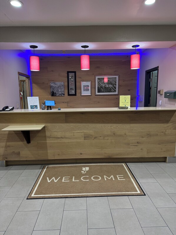 Welcome to our reception area, featuring a warm and inviting space with a bench, pendant lights, and a selection of artwork on the walls.