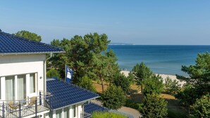 Une propriété située sur la côte, dotée d’un balcon donnant sur la mer et entourée d’arbres.