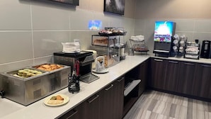 A self-service breakfast bar with various food items and a coffee machine. - Super 8 by Wyndham Macleod Trail Calgary (Calgary)
