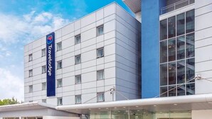 A Travelodge hotel with a modern facade, large windows, and outdoor seating areas. - Travelodge London Docklands (London)