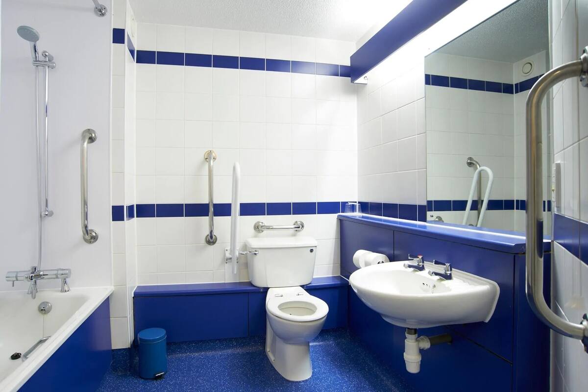 A bathroom with a white toilet, a sink, and a shower.