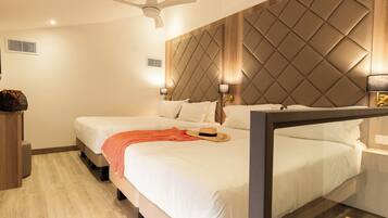A hotel room with a bed, bedside lamps, a ceiling fan, and a wooden headboard.