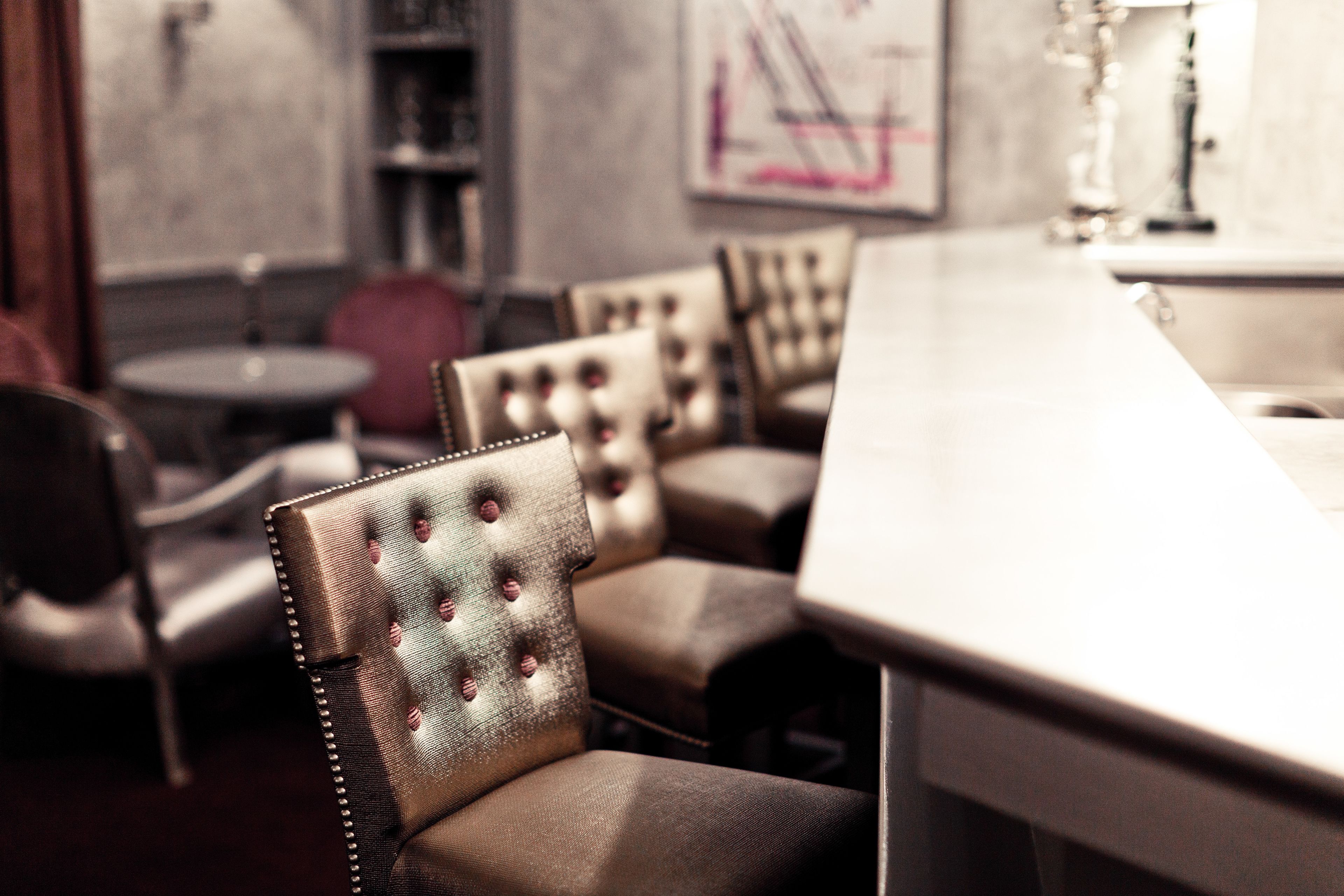 A bar area with leather chairs and a bar counter.