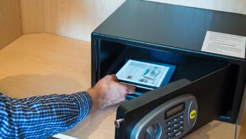 A person using a microwave with a digital display and keypad, placed on a wooden surface.