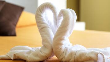 Una cama con una toalla blanca doblada en forma de corazón.