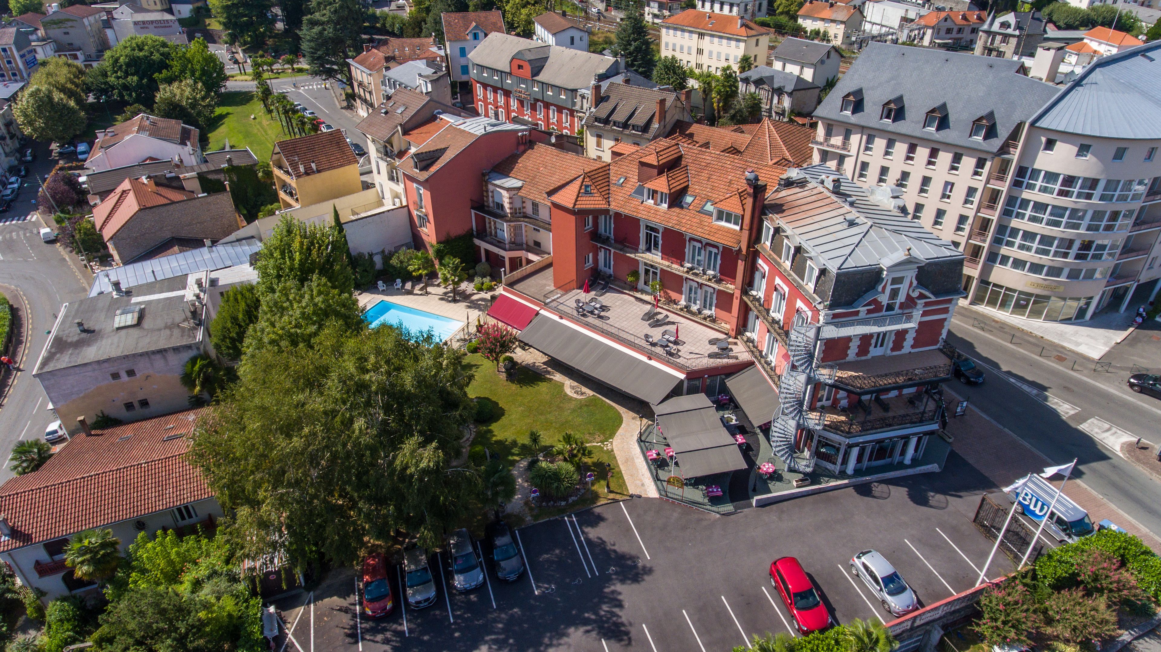 Ein Luftbild eines Hotels mit Dachpool, mehreren Etagen und einem Parkplatz.