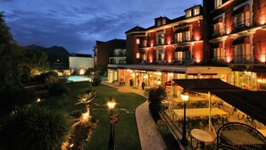 Un hotel con piscina, zona de estar al aire libre y entrada bien iluminada.