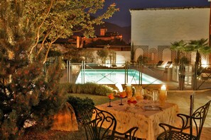 Una piscina al aire libre de temporada, sombrillas