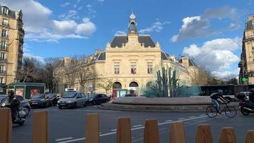 A historic building with classical architecture, a roundabout, and a clear blue sky.