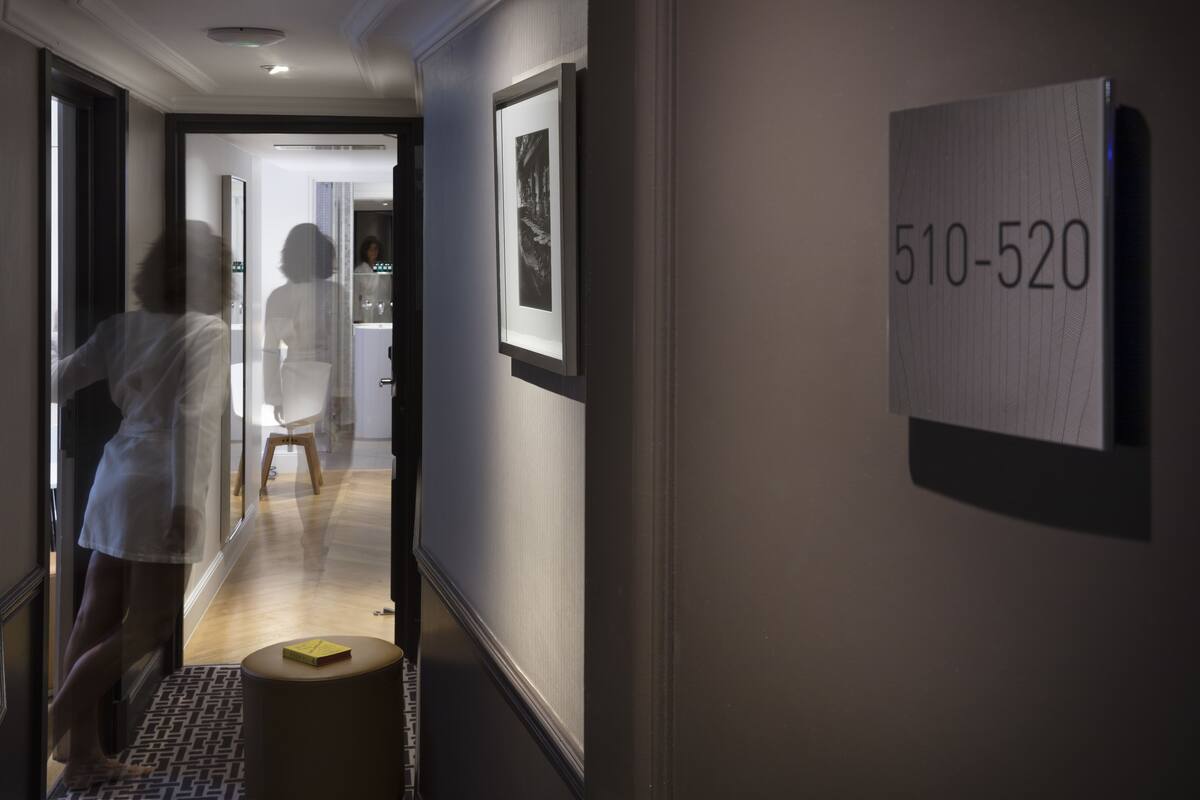 A hallway with a number sign '510-520' on the wall, a framed picture, and a small round table with a yellow object on it.