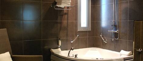 A modern bathroom with a freestanding bathtub, a showerhead, and a towel rack.