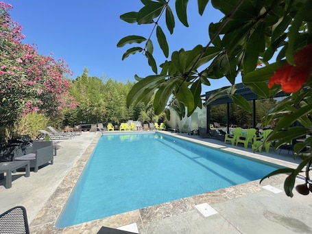 Seasonal outdoor pool, pool umbrellas, sun loungers. Logis Hôtel Nimotel