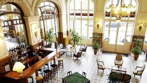 A spacious lobby with a bar area, multiple seating arrangements, and large windows allowing natural light. - Du Soleil Le Terminus (Carcassonne)