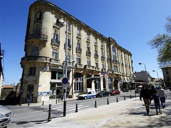 A historic building with multiple floors, large windows, and balconies. - Du Soleil Le Terminus (Carcassonne)