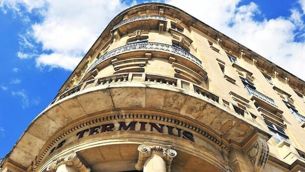 A building with a classical architectural style, featuring a prominent arched entrance with the inscription "Terminus." - Du Soleil Le Terminus (Carcassonne)