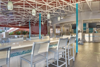 A hotel room with a bed, bedside tables, a desk, a chair, a balcony with curtains, and a ceiling fan. at Hilton Grand Vacations Club SeaWorld® Orlando