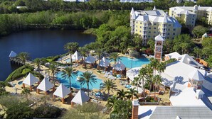 Un resort con una piscina grande, palmeras y vistas del entorno.