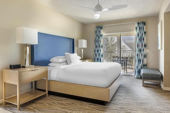 A spacious lobby with a patterned carpet, multiple seating areas, a television, and a reception desk. at Hilton Grand Vacations Club SeaWorld® Orlando