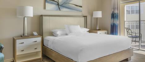 Une chambre d’hôtel avec un lit, deux tables de chevet, une chaise, une fenêtre avec des rideaux et un tableau au mur.