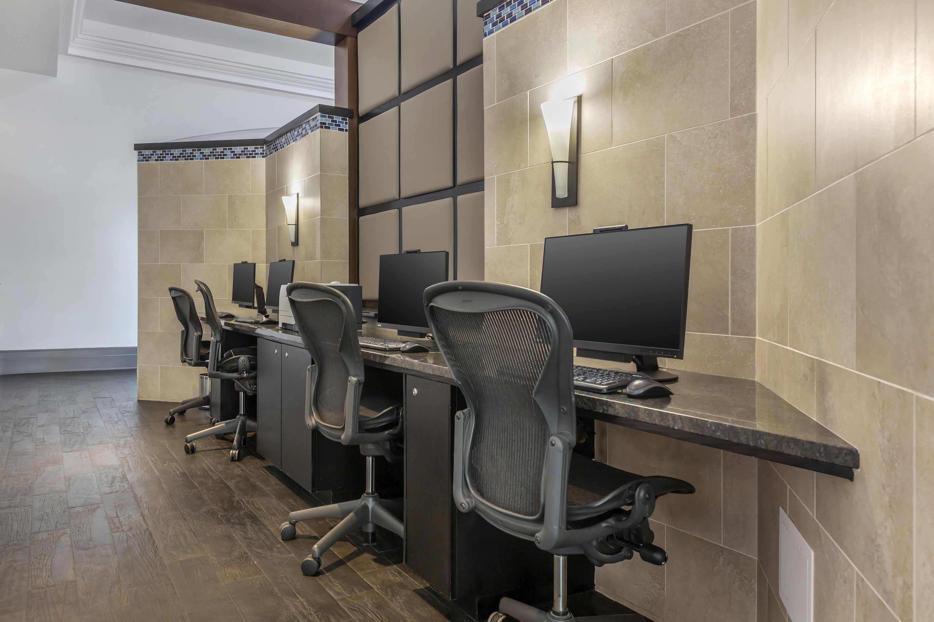 A conference room with multiple desks, chairs, and computer monitors.