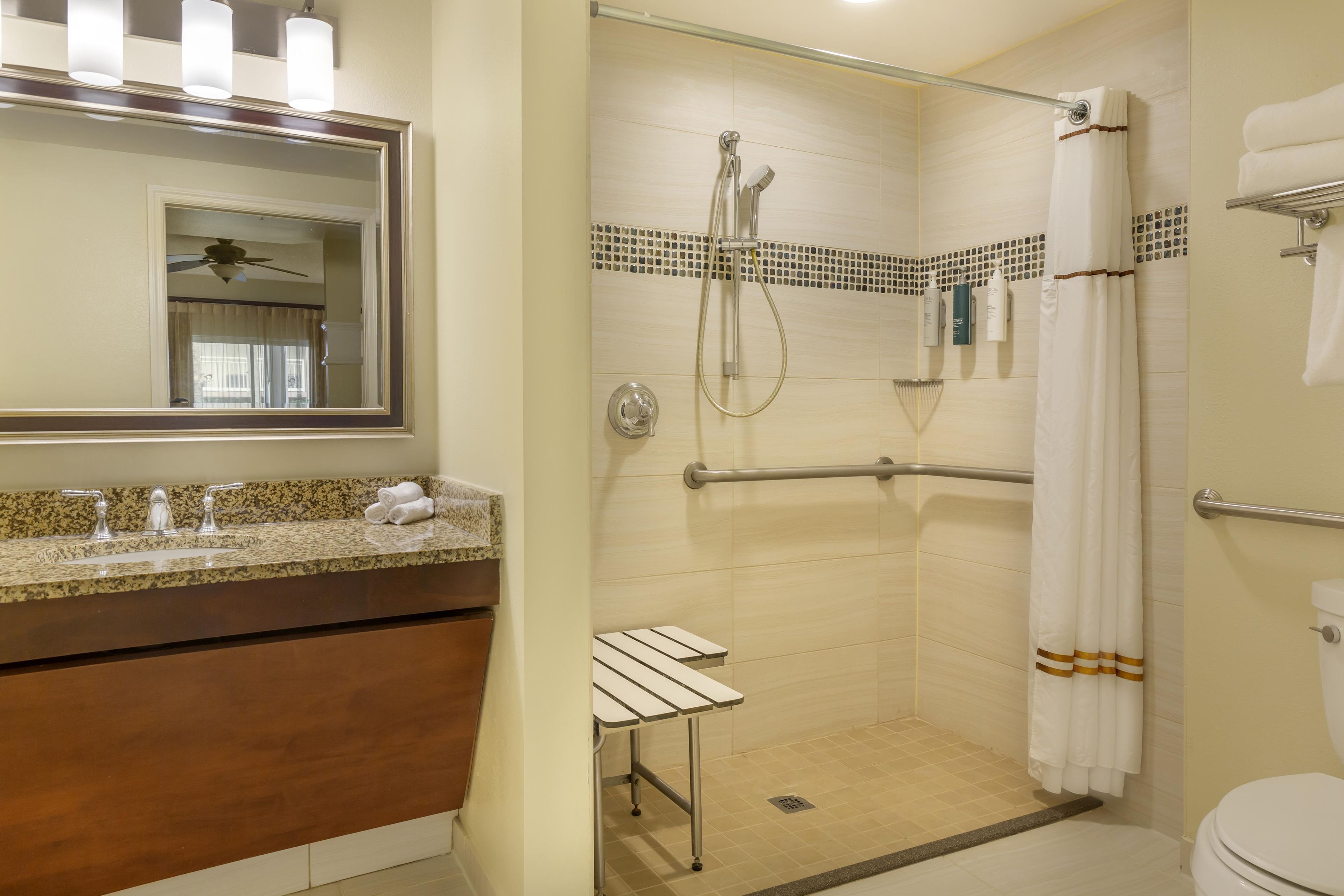 Une salle de bain avec douche, toilettes et lavabo.